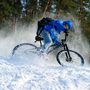 Mężczyzna jeździ na rowerze po zaśnieżonym lesie
