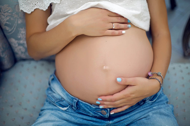 Kobieta pokazująca wygląd brzucha w 3 trymestrze ciąży