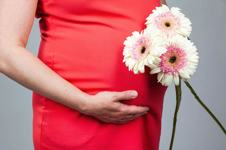 Kobieta dotykająca brzucha w okresie 1 trymestru ciąży