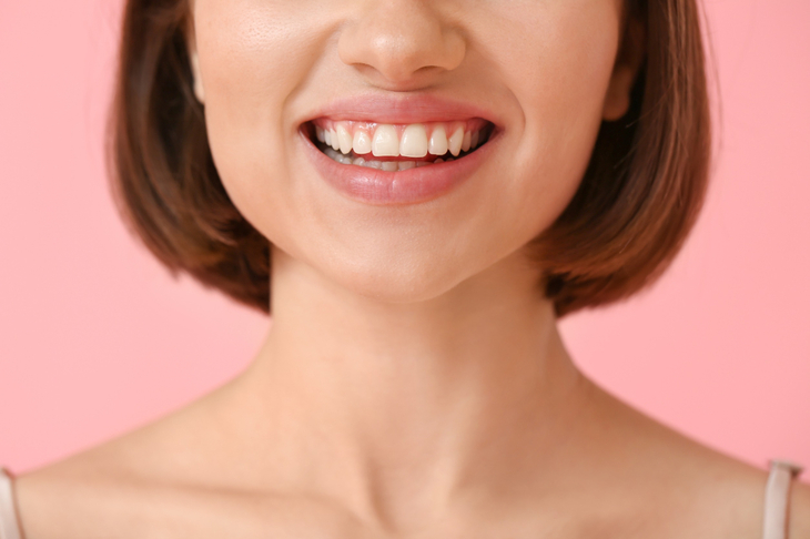 Uśmiechnięta kobieta po zastosowaniu leku na odrastanie zębów