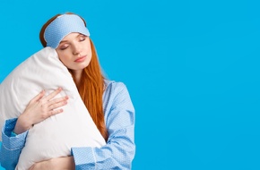 Kobieta w opasce do snu trzymająca poduszkę