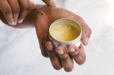 Naturalny balsam do pielęgnacji skóry trzymany w dłoniach, kosmetyk nawilżający do ciała