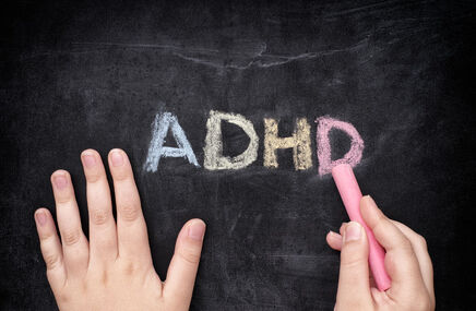 Wyraz ADHD napisany krędą na tablicy