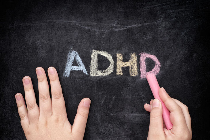 Wyraz ADHD napisany krędą na tablicy