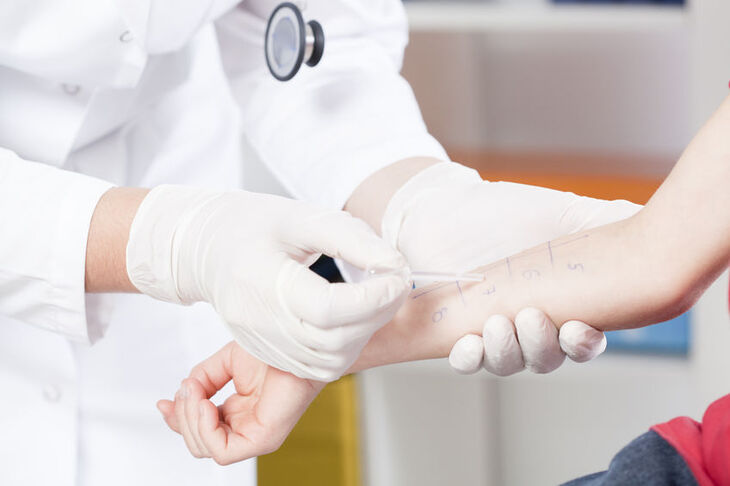 Lekarz trzymający osobę za nadgarstek w czasie wykonywania testów skórnych