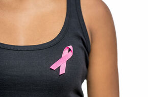Różowa kokardka na koszulce symbolizująca walkę z rakiem