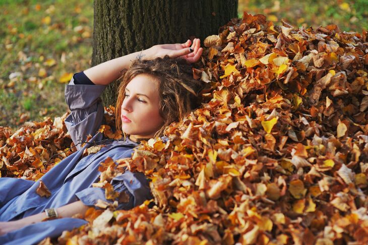 Kobieta leżąca w jesiennych liściach