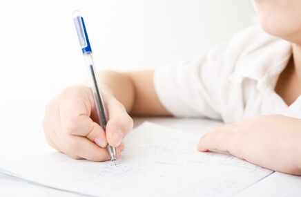 Dziecko piszące długopisem w zeszycie