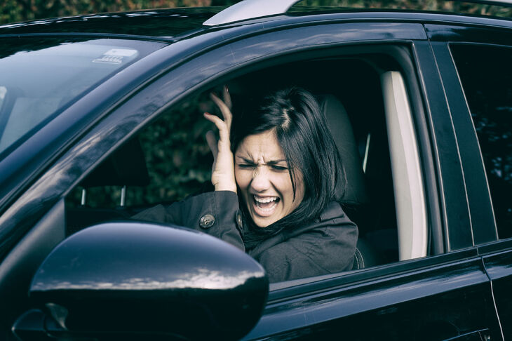 Przerażona kobieta siedząca za kierownicą samochodu