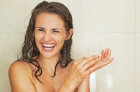 Uśmiechnięta kobieta pod prysznicem