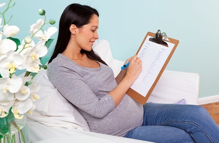 Kobieta w zaawansowanej ciąży trzymająca w dłoni plan porodu