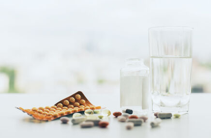 Tabletki oraz szklanka z wodą