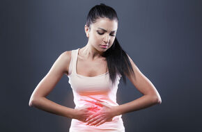 Kobieta cierpiąca z powodu bólu żołądka po jedzeniu